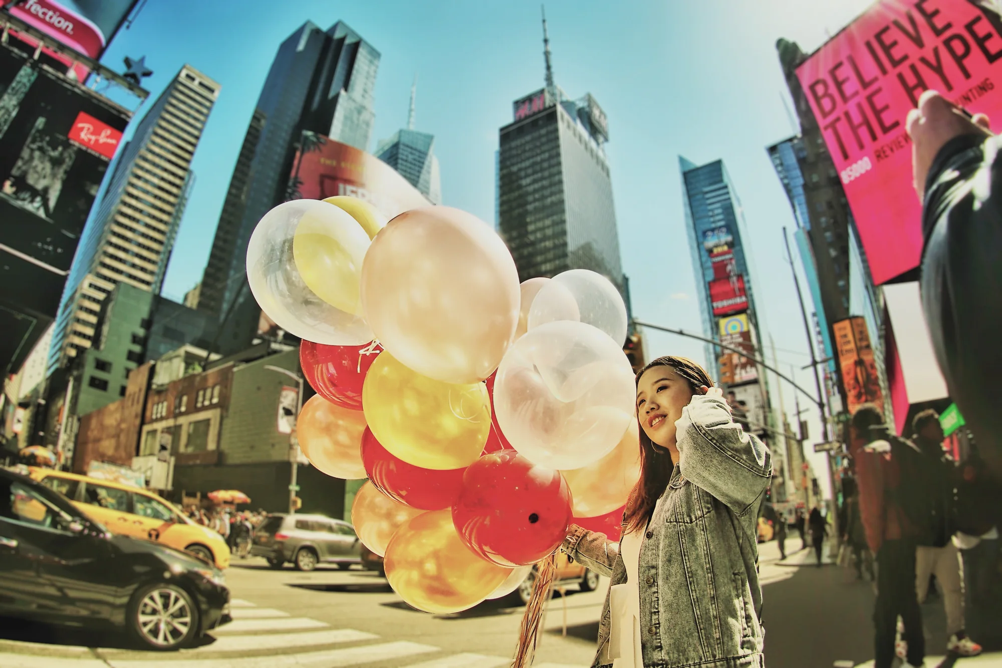 Nő világos lufikkal a Times Square forgatagában